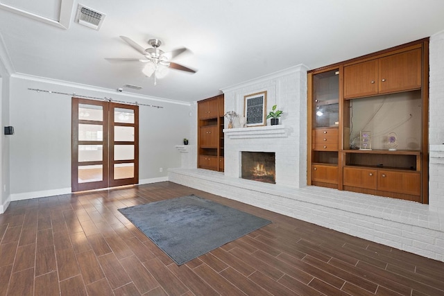 1101 Mahan Dr, Austin, TX 78721 - unfurnished living room with ceiling fan, dark wood-style floors, a fireplace, and crown molding