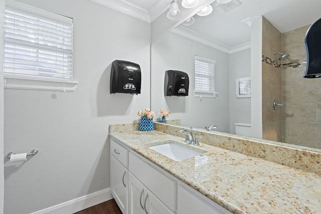 1101 Mahan Dr, Austin, TX 78721 - bathroom featuring crown molding, vanity, a tile shower, and wood finished floors