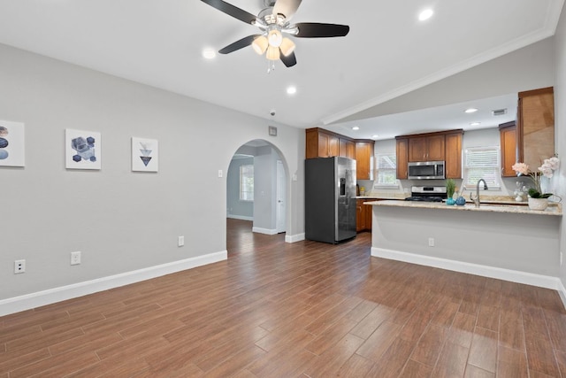1101 Mahan Dr, Austin, TX 78721 - kitchen with appliances with stainless steel finishes, open floor plan, ceiling fan, arched walkways, and a peninsula