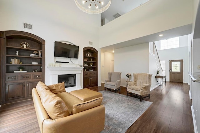 3612 Short Horn Ln, Round Rock, TX 78665 - living room with a high ceiling, built in shelves, a fireplace, and wood finished floors