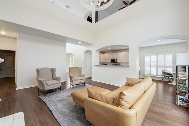3612 Short Horn Ln, Round Rock, TX 78665 - living area with arched walkways, dark wood-style floors, and recessed lighting