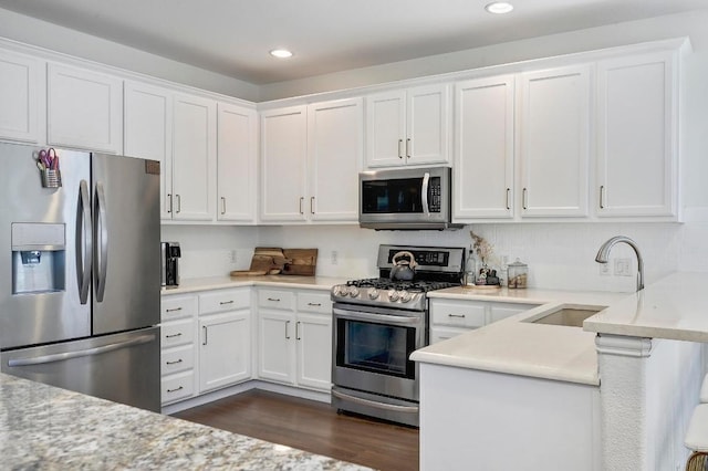3612 Short Horn Ln, Round Rock, TX 78665 - kitchen featuring appliances with stainless steel finishes, white cabinetry, dark wood-style floors, a peninsula, and recessed lighting