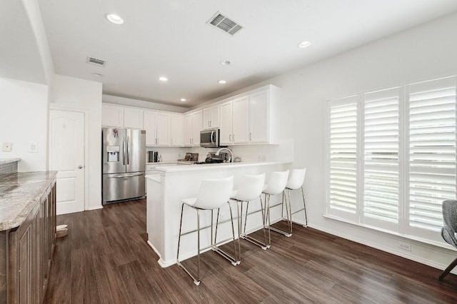 3612 Short Horn Ln, Round Rock, TX 78665 - kitchen with stainless steel appliances, a peninsula, dark wood-style floors, white cabinetry, and recessed lighting