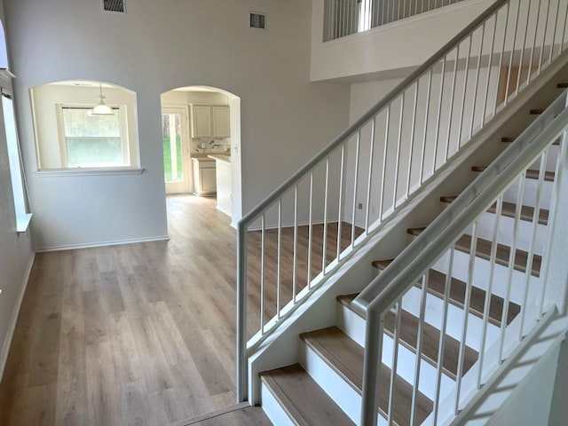 15316 Lady Elizabeth Ln, Pflugerville, TX 78660 - stairway with a towering ceiling, arched walkways, and wood finished floors