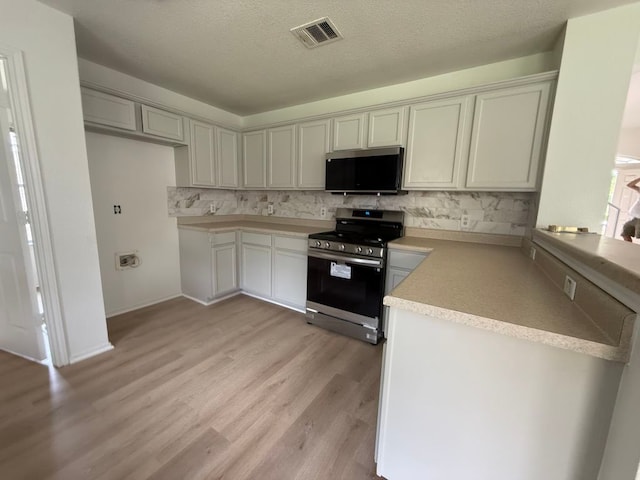 15316 Lady Elizabeth Ln, Pflugerville, TX 78660 - kitchen featuring stainless steel appliances, backsplash, light wood-style floors, light countertops, and a textured ceiling