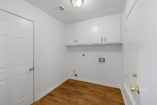 3419 Bluebonnet Trl, Georgetown, TX 78628 - washroom with cabinet space, hookup for an electric dryer, hookup for a washing machine, wood finished floors, and gas dryer hookup