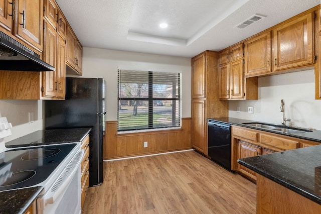 3419 Bluebonnet Trl, Georgetown, TX 78628 - kitchen with white range with electric stovetop, ventilation hood, black dishwasher, light wood finished floors, and wainscoting