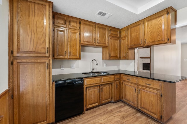 3419 Bluebonnet Trl, Georgetown, TX 78628 - kitchen with black dishwasher, brown cabinets, a peninsula, and light wood-style flooring