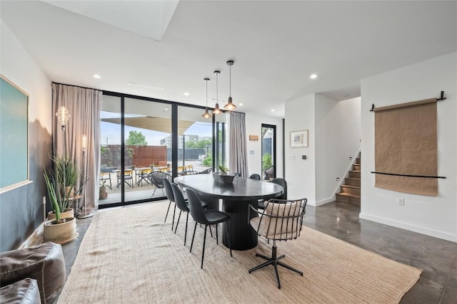2309 E 5th St, Austin, TX 78702 - dining room featuring concrete floors, stairs, a wall of windows, and recessed lighting