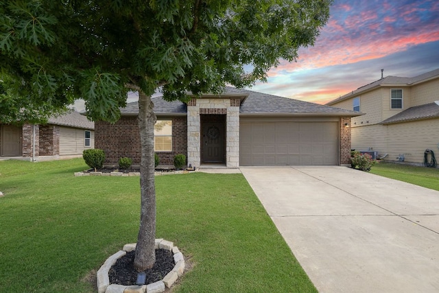 413 Luna Vista Dr, Hutto, TX 78634 - view of front of house featuring an attached garage, a yard, brick siding, driveway, and a shingled roof