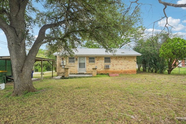 1620 Cavett St, Gonzales, TX 78629 - back of property featuring a lawn, brick siding, and a carport