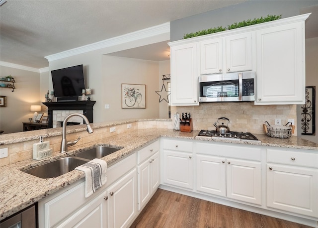 401 Kimra Cv, Georgetown, TX 78628 - kitchen with appliances with stainless steel finishes, tasteful backsplash, crown molding, wood finished floors, and light stone countertops