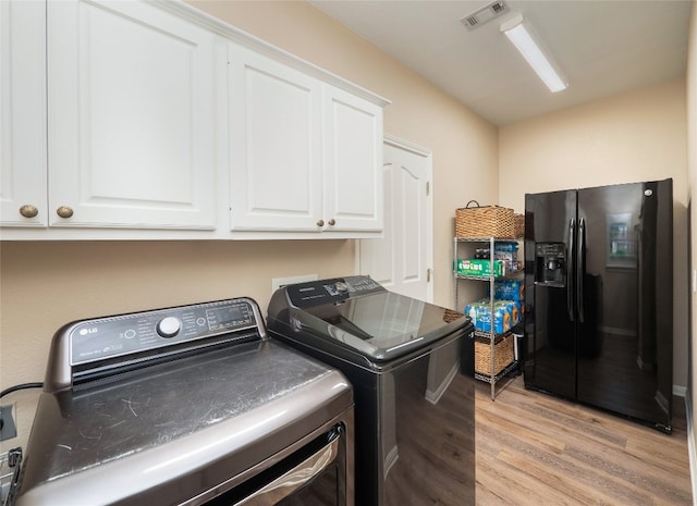 401 Kimra Cv, Georgetown, TX 78628 - laundry room with cabinet space, separate washer and dryer, and light wood finished floors