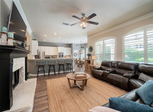 401 Kimra Cv, Georgetown, TX 78628 - living room with ornamental molding, ceiling fan, light wood finished floors, and a fireplace