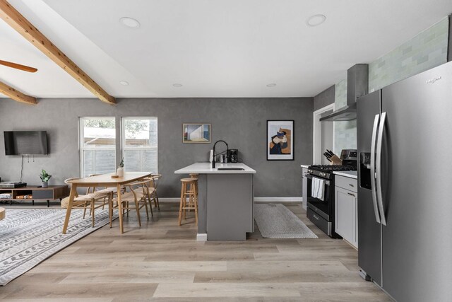4911 Brighton Rd, Austin, TX 78745 - kitchen with appliances with stainless steel finishes, wall chimney range hood, light countertops, light wood-style floors, and recessed lighting