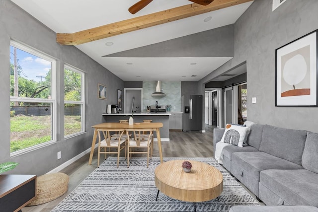 4911 Brighton Rd, Austin, TX 78745 - living room featuring light wood finished floors, beamed ceiling, ceiling fan, and a barn door