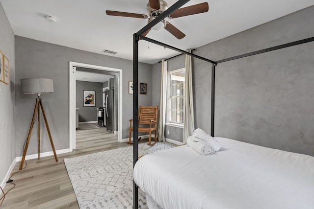 4911 Brighton Rd, Austin, TX 78745 - bedroom with light wood finished floors, freestanding refrigerator, and ceiling fan