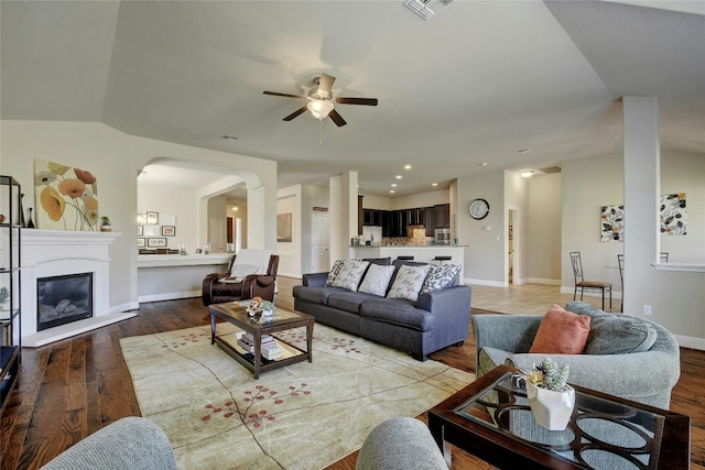 578 Ledge Stone Dr, Austin, TX 78737 - living room with a ceiling fan, light wood-style flooring, arched walkways, recessed lighting, and a glass covered fireplace