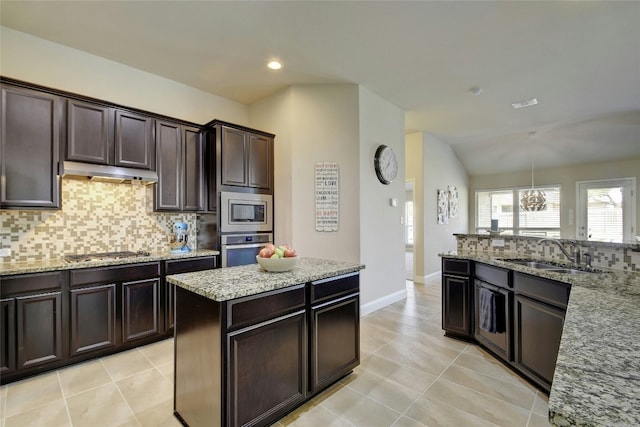 578 Ledge Stone Dr, Austin, TX 78737 - kitchen with appliances with stainless steel finishes, under cabinet range hood, backsplash, light stone counters, and recessed lighting