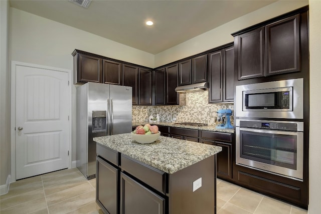 578 Ledge Stone Dr, Austin, TX 78737 - kitchen featuring stainless steel appliances, under cabinet range hood, a kitchen island, light tile patterned flooring, and recessed lighting