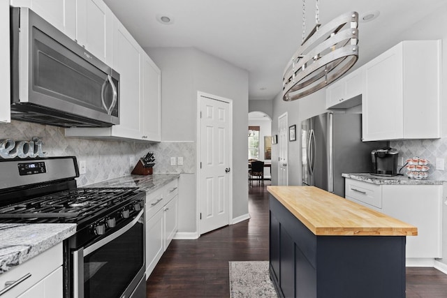 4112 Seldalia Trl, Austin, TX 78732 - kitchen featuring appliances with stainless steel finishes, wooden counters, arched walkways, dark wood-type flooring, and white cabinetry