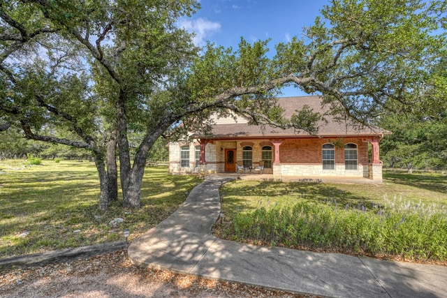1050 Twisted Oak Dr, Horseshoe Bay, TX 78657 - view of front of house featuring a porch, a front yard, and stone siding