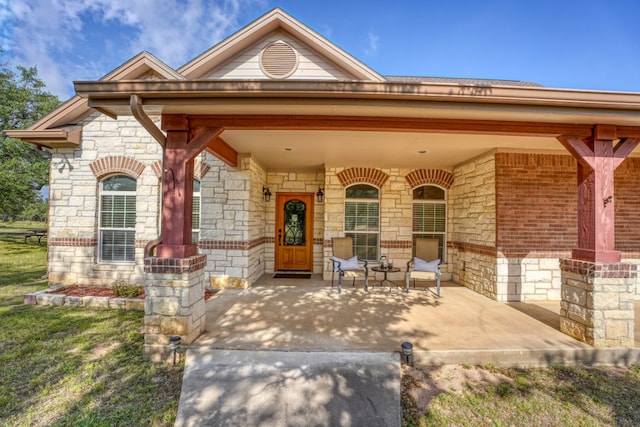 1050 Twisted Oak Dr, Horseshoe Bay, TX 78657 - entrance to property with stone siding, a porch, and brick siding