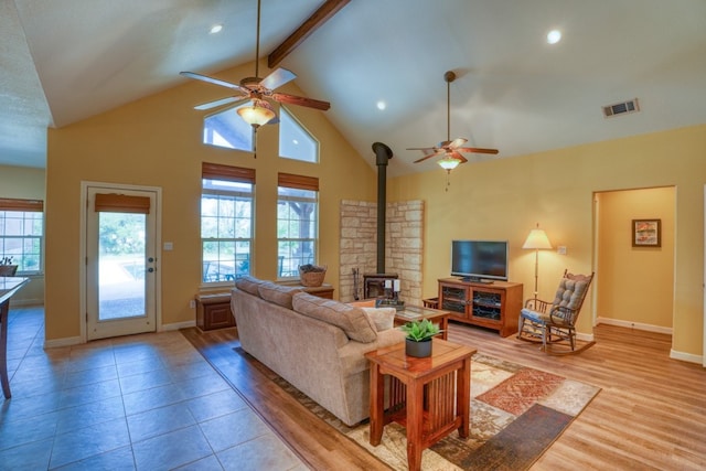 1050 Twisted Oak Dr, Horseshoe Bay, TX 78657 - living room with ceiling fan, a wood stove, plenty of natural light, beamed ceiling, and recessed lighting