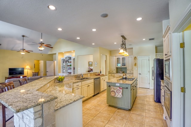 1050 Twisted Oak Dr, Horseshoe Bay, TX 78657 - kitchen featuring appliances with stainless steel finishes, a large island with sink, light tile patterned floors, a breakfast bar area, and vaulted ceiling