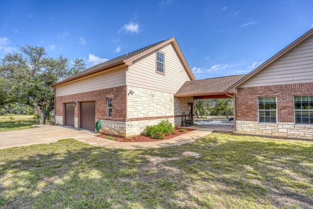 1050 Twisted Oak Dr, Horseshoe Bay, TX 78657 - view of home's exterior featuring stone siding, a lawn, concrete driveway, brick siding, and roof with shingles