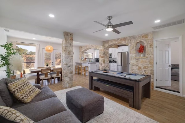 17708 Cherry Ln, Lago Vista, TX 78645 - living room featuring ornate columns, light wood-style floors, a ceiling fan, arched walkways, and recessed lighting