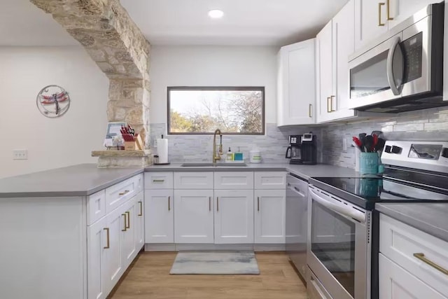 17708 Cherry Ln, Lago Vista, TX 78645 - kitchen featuring stainless steel appliances, white cabinets, tasteful backsplash, a peninsula, and recessed lighting
