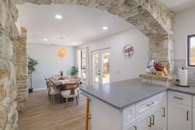 17708 Cherry Ln, Lago Vista, TX 78645 - kitchen with light wood-style floors, white cabinetry, a peninsula, recessed lighting, and a breakfast bar
