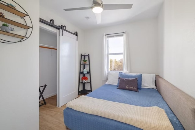 17708 Cherry Ln, Lago Vista, TX 78645 - bedroom with a barn door, wood finished floors, and a ceiling fan