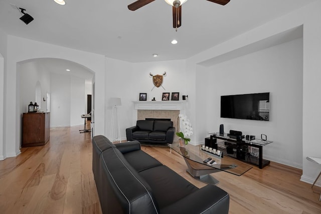 15800 Tetons Ct, Bee Cave, TX 78738 - living area featuring arched walkways, ceiling fan, light wood-style flooring, recessed lighting, and a tile fireplace