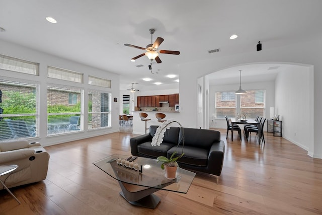 15800 Tetons Ct, Bee Cave, TX 78738 - living room with arched walkways, a ceiling fan, light wood finished floors, and recessed lighting