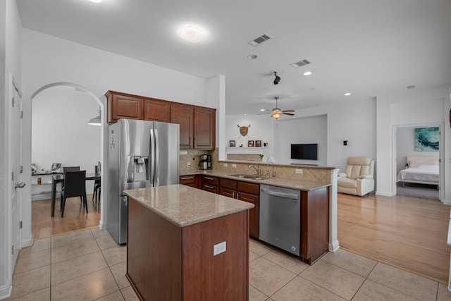 15800 Tetons Ct, Bee Cave, TX 78738 - kitchen featuring appliances with stainless steel finishes, a peninsula, open floor plan, light tile patterned floors, and recessed lighting