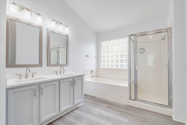 911 Bogart Rd, Cedar Park, TX 78613 - bathroom with a garden tub, double vanity, a stall shower, and wood finished floors