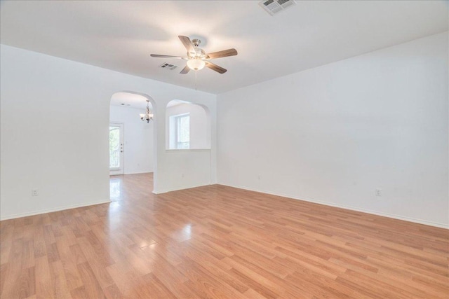 911 Bogart Rd, Cedar Park, TX 78613 - empty room featuring arched walkways, ceiling fan, light wood-type flooring, and a chandelier