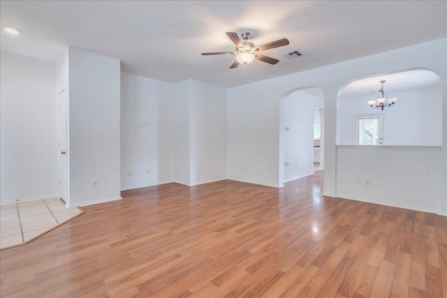 911 Bogart Rd, Cedar Park, TX 78613 - empty room with arched walkways, a ceiling fan, light wood-style floors, and a chandelier