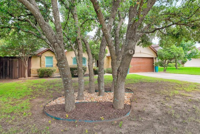 30613 Chi Chi Dr, Georgetown, TX 78628 - obstructed view of property with driveway, an attached garage, and stucco siding