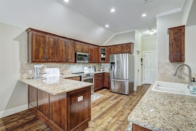 30613 Chi Chi Dr, Georgetown, TX 78628 - kitchen with crown molding, a peninsula, stainless steel appliances, vaulted ceiling, and backsplash