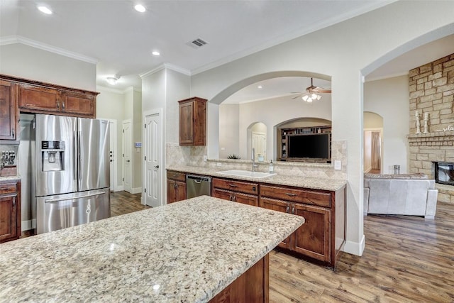 30613 Chi Chi Dr, Georgetown, TX 78628 - kitchen featuring ceiling fan, appliances with stainless steel finishes, open floor plan, ornamental molding, and light stone counters