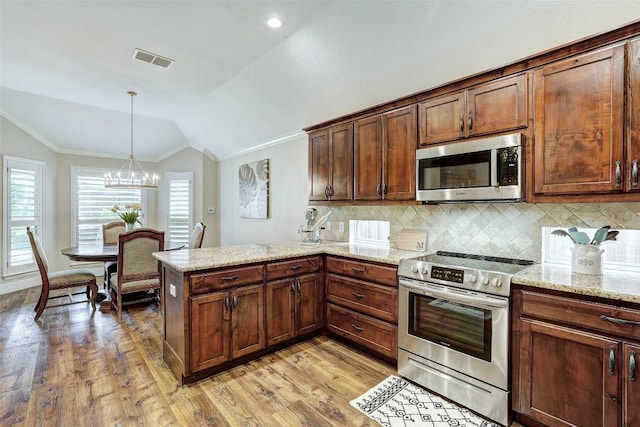 30613 Chi Chi Dr, Georgetown, TX 78628 - kitchen featuring appliances with stainless steel finishes, crown molding, a peninsula, light wood-type flooring, and vaulted ceiling