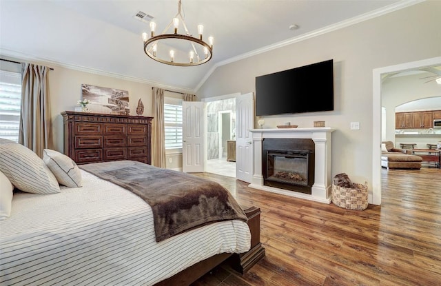 30613 Chi Chi Dr, Georgetown, TX 78628 - bedroom with wood finished floors, ornamental molding, lofted ceiling, a chandelier, and a glass covered fireplace