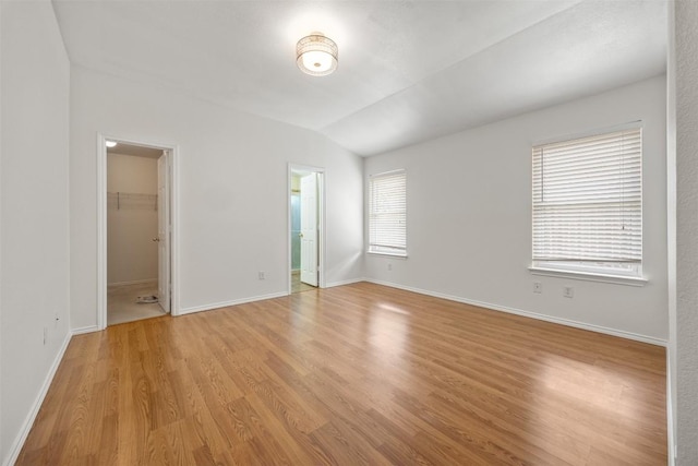3710 Castle Rock Dr, Round Rock, TX 78681 - unfurnished bedroom featuring light wood finished floors, a walk in closet, lofted ceiling, and connected bathroom