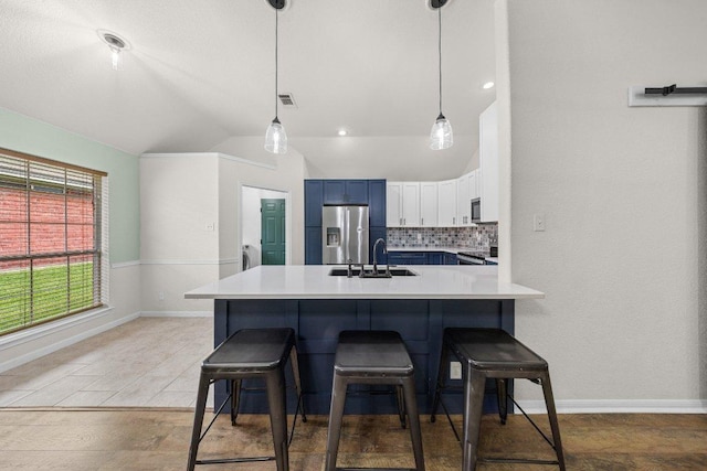 1409 Castle Ridge Dr, Harker Heights, TX 76548 - kitchen with appliances with stainless steel finishes, vaulted ceiling, a breakfast bar area, blue cabinetry, and light countertops