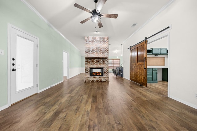1409 Castle Ridge Dr, Harker Heights, TX 76548 - unfurnished living room with ceiling fan, wood finished floors, crown molding, a brick fireplace, and a barn door