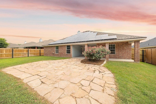 1409 Castle Ridge Dr, Harker Heights, TX 76548 - rear view of property with brick siding, roof mounted solar panels, a fenced backyard, and a carport