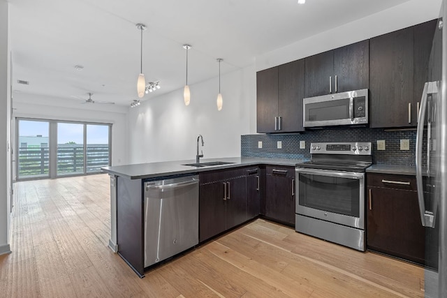 3600 S Lamar Blvd Unit 501, Austin, TX 78704 - kitchen featuring appliances with stainless steel finishes, decorative backsplash, light wood-style floors, a peninsula, and open floor plan